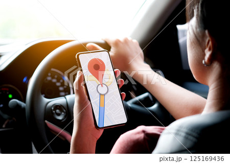 A woman car driving on the road And she is looking for a GPS map on a smartphone to get to the destination of the route. Concept of technology and road traffic 125169436