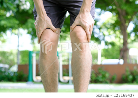 Knee pain .man stand at park Her hand caught at the knee. Having painful feet and stretching muscles fatigue To relieve pain. health concepts 125169437