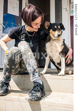 Dog in the shelter. Animal shelter volunteer takes care of dogs. Dog in the shelter. Animal shelter volunteer takes care of dogs. 125170908