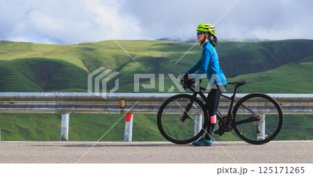 Woman cyclist with road bike ready to hit the road 125171265