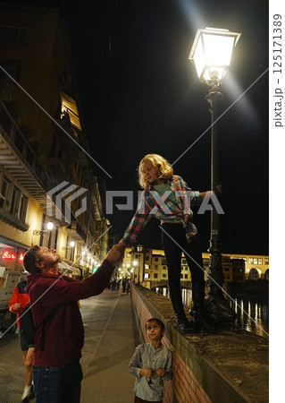Nighttime Playful Moment Under Streetlight on Bridge Nighttime Playful Moment Under Streetlight on Bridge 125171389