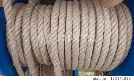 A Beautifully Coiled Natural Rope Set Against a Striking Blue Background for Visual Impact 125171858