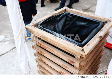 A Wooden Trash Bin Strategically Placed at an Outdoor Community Event for Cleanliness 125172145