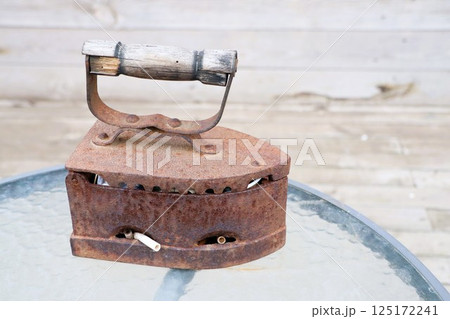 A Beautiful Vintage Rusty Iron on a Glass Table, Perfect for Any Home Decor Style 125172241