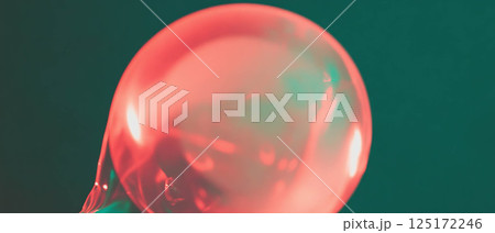 A vibrant bubblegum bubble grows larger, revealing fascinating textures and colors. 125172246