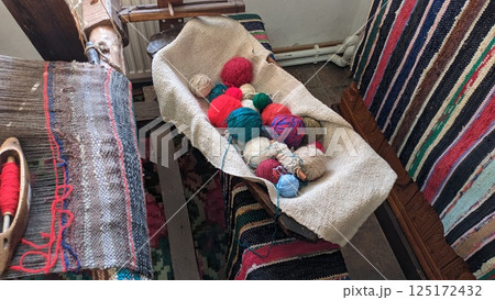 Vibrantly Colorful Yarn Balls Arranged Beautifully in a Handwoven Textile Setting 125172432