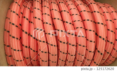 A coiled pink rope that features decorative black dots, perfect for a variety of uses 125172620