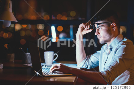 Busy Office Manager Working On Laptop Overnight Sitting At Workplace Indoors. Selective Focus, Low Light 125172996