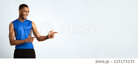Great Promo. Happy black sportive guy pointing two index fingers aside at copy space over yellow studio background Great Promo. Happy black sportive guy pointing two index fingers aside at copy space over yellow studio background 125173235