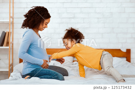 Waiting For Brother. Little Girl Touching Mom's Pregnant Belly Sitting In Bed At Home 125173432