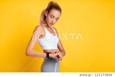 Fitness Tracker. Sporty Girl Using Smartwatch Or Heart Rate Monitor During Workout On Pink Studio Background. Empty Space Fitness Tracker. Sporty Girl Using Smartwatch Or Heart Rate Monitor During Workout On Pink Studio Background. Empty Space 125173606