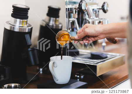 Woman barista pouring hot coffee intop white mug. Woman barista pouring hot coffee intop white mug. 125173867