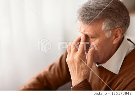 Depression In Older Age. Desperate Elderly Man Thinking About Loneliness Touching Nosebridge Sitting On Couch At Home. Free Space 125173948