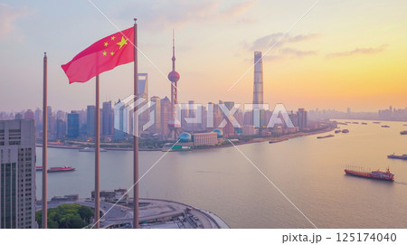 Vibrant sunset skyline of Shanghai with the China flag waving proudly over the Huangpu River 125174040