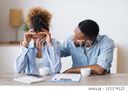 Afro Husband Comforting His Wife Crying On Family Or Adoption Counseling. Selective Focus Afro Husband Comforting His Wife Crying On Family Or Adoption Counseling. Selective Focus 125174125