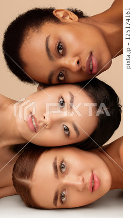 Beauty. Portrait Of Three Multiethnic Models Girls With Perfect Face Skin Posing Over Gray Studio Background. Vertical Panorama 125174161