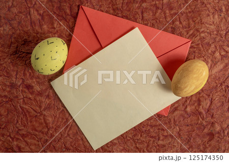 Easter themed flat lay with decorative eggs, envelope, and rustic background. Easter themed flat lay with decorative eggs, envelope, and rustic background. 125174350