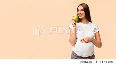 Pregnancy And Healthy Nutrition. Expectant Girl Eating Apple Touching Belly Standing On White Studio Background. Panorama With Free Space Pregnancy And Healthy Nutrition. Expectant Girl Eating Apple Touching Belly Standing On White Studio Background. Panorama With Free Space 125174366