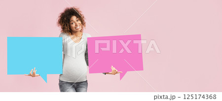 Choose names for twins. African-american expectant woman holding blue and pink speech bubbles Choose names for twins. African-american expectant woman holding blue and pink speech bubbles 125174368