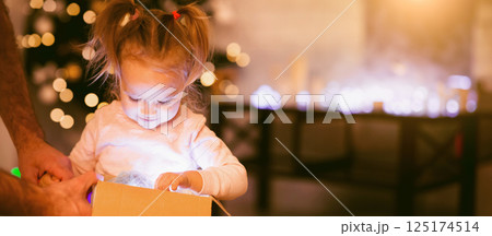 Cherished present. Little girl enjoying her glowing Christmas present at home Cherished present. Little girl enjoying her glowing Christmas present at home 125174514