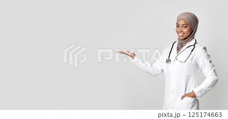 Effective Flu Remedy. Young Black Female Doctor Holding Invisible Item On Her Palm, Showing New Vitamin Complex, Demonstrating Pack With Medicine Effective Flu Remedy. Young Black Female Doctor Holding Invisible Item On Her Palm, Showing New Vitamin Complex, Demonstrating Pack With Medicine 125174663