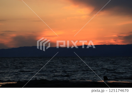 江ノ島岩屋近くの稚児ヶ淵（ちごがふち）で夕陽を眺める人　夕景 125174670