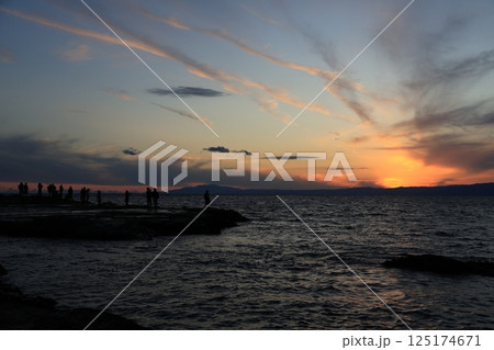 江ノ島岩屋近くの稚児ヶ淵(ちごがふち)で夕陽を眺める人 夕景 江ノ島岩屋近くの稚児ヶ淵(ちごがふち)で夕陽を眺める人 夕景 125174671