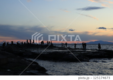 江ノ島岩屋近くの稚児ヶ淵(ちごがふち)で夕陽を眺める人 夕景 江ノ島岩屋近くの稚児ヶ淵(ちごがふち)で夕陽を眺める人 夕景 125174673