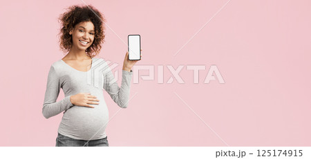 Cool app. Happy pregnant woman showing phone with blank screen over pink background Cool app. Happy pregnant woman showing phone with blank screen over pink background 125174915