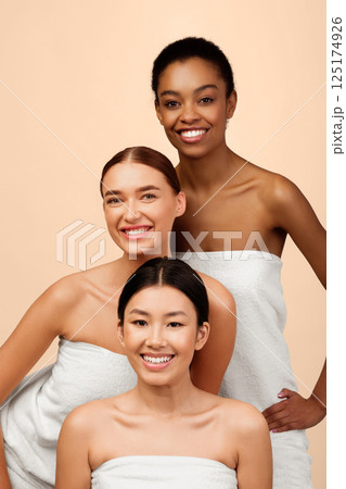 Three Multicultural Women In Bath Towels Posing In Studio On White Background. Female Group Beauty Portrait Three Multicultural Women In Bath Towels Posing In Studio On White Background. Female Group Beauty Portrait 125174926