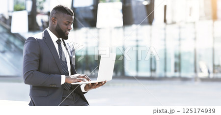Successful Afro Entrepreneur Working On Laptop During Coffee Break In City. Empty Space 125174939