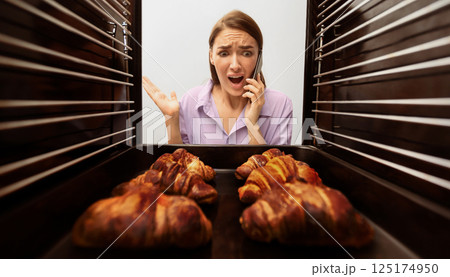 Failed recipe. Emotional woman calling for mother support, looking at baking in oven, view from inside 125174950