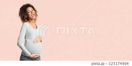 Excited african-american pregnant woman touching belly and laughing on white background Excited african-american pregnant woman touching belly and laughing on white background 125174984