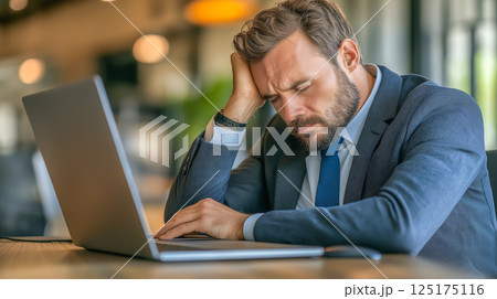 Rear view photo of businessman feels headache at a office company 125175116