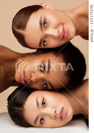 Multiracial Beauty. Portrait Of Multiethnic Asian, African American And Caucasian Women Looking At Camera Posing Over Gray Studio Background. Vertical Multiracial Beauty. Portrait Of Multiethnic Asian, African American And Caucasian Women Looking At Camera Posing Over Gray Studio Background. Vertical 125175246