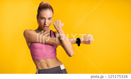 Motivated Fitness Woman Doing Arm Stretch Exercise Standing Over Pink Studio Background. Panorama Motivated Fitness Woman Doing Arm Stretch Exercise Standing Over Pink Studio Background. Panorama 125175326