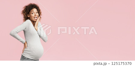 Pregnancy concept. Surprised black woman posing over pink studio background Pregnancy concept. Surprised black woman posing over pink studio background 125175370