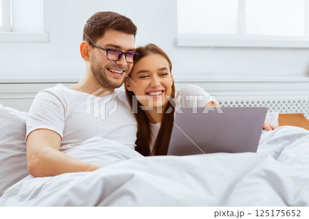 Weekend Together. Happy Couple Watching Film On Laptop Sitting In Bed At Home. Selective Focus 125175652