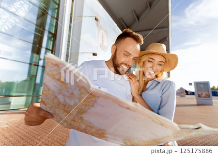 Plan route. Couple looking at map against airport terminal building 125175886