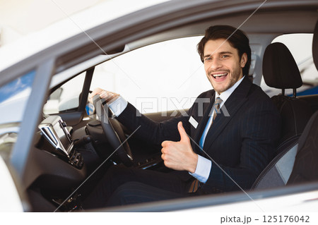 Great Offer. Man Buying Car Gesturing Thumbs Up Sitting In Driver's Seat Testing Auto In Dealership Showroom Great Offer. Man Buying Car Gesturing Thumbs Up Sitting In Driver's Seat Testing Auto In Dealership Showroom 125176042