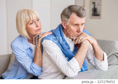 Problems in relationships. Senior woman consoling husband after arguing at home Problems in relationships. Senior woman consoling husband after arguing at home 125176052