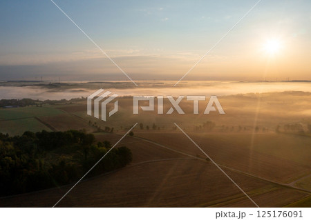 Drone aerial view at sunrise with rolling landscapes covered in fog 125176091