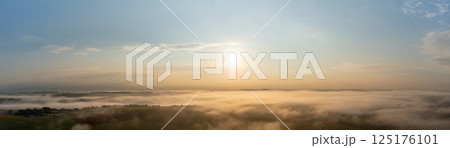 Drone panorama with golden light illuminating foggy agricultural fields and rolling hills Drone panorama with golden light illuminating foggy agricultural fields and rolling hills 125176101