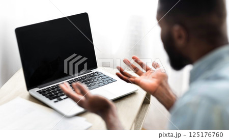 No way. Worried african american guy looking at laptop with blank screen. Over shoulder shot, selective focus on device 125176760