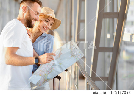 Happy couple waiting to board a plane and looking at the map of the tourist destinations they want to visit, copy space Happy couple waiting to board a plane and looking at the map of the tourist destinations they want to visit, copy space 125177058