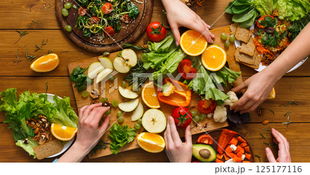 Healthy food dinner table. Women at home together, eating fruits and vegetables, top view, flat lay, crop 125177116