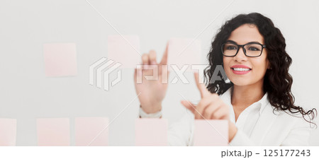 Business Plan. Smiling mexican businesswoman sharing her ideas on sticky notes over glass wall at office Business Plan. Smiling mexican businesswoman sharing her ideas on sticky notes over glass wall at office 125177243