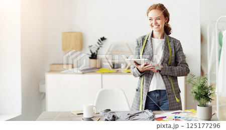 Fashion designer drawing new sketches collection on tablet, working in designers stylish showroom 125177296