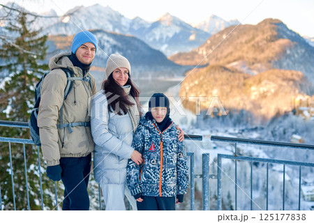 Golden Hour Family Adventure Snowy Mountain Panorama with Parents and Child Overlooking Serene Lake Landscape Capturing Warm Winter Bonding Moment in Nature Golden Hour Family Adventure Snowy Mountain Panorama with Parents and Child Overlooking Serene Lake Landscape Capturing Warm Winter Bonding Moment in Nature 125177838