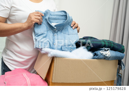 Donation box with used clothes at home to support help for poor people in the world. 125179828